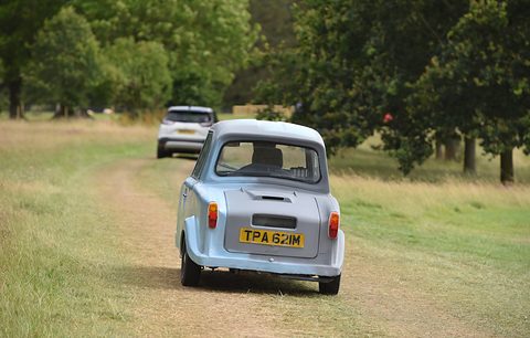 Rear of a pale blue single-seat three-wheeler on a mown track between trees. Opens a larger view