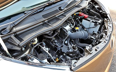Open bonnet of a small brown car showing a compact engine, battery and pipes under the scuttle panel. Opens a larger view