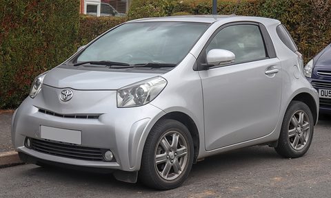 Silver short three-door hatchback with alloy wheels parked on a road beside a hedge, its number plate blanked. Opens a larger view