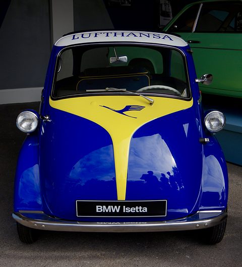Dark blue bubble car with a yellow crane-logo stripe and Lufthansa script on the roof. Opens a larger view