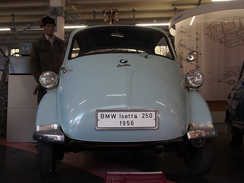 Pale blue bubble car seen straight from the front with a plate reading BMW Isetta 250 1956. Opens a larger view