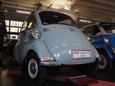 Pale blue bubble car on a museum floor, seen from the front left. Opens a larger view