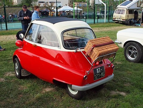 Red and white bubble car from behind with a wicker hamper on the chrome rack. Opens a larger view