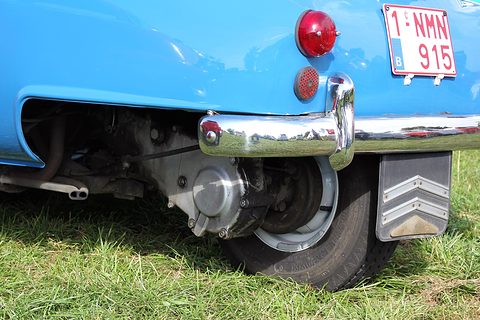Low view of a blue bubble car’s tail showing one rear wheel on a swinging arm and a mudflap. Opens a larger view