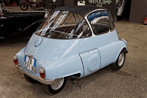 Pale blue bubble car from the left rear: wraparound rear window, French plate and two narrow-set rear wheels. Opens a larger view