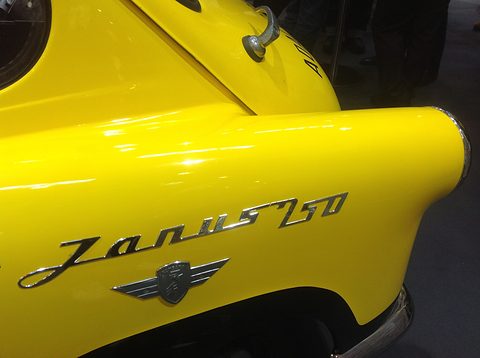 Chrome Janus 250 script and winged badge on bright yellow paint, a chrome mirror above. Opens a larger view