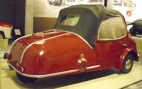 Maroon three-wheeler from the rear with a vented tail, black hood and a chrome side strip. Opens a larger view