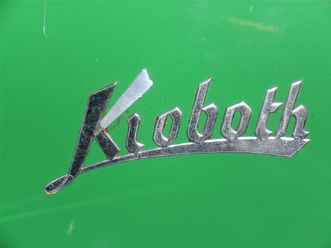Chrome Kroboth script in sloping handwriting on glossy green paint. Opens a larger view