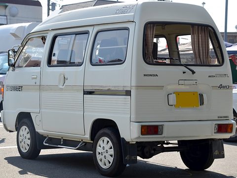 Rear three-quarter of a white high-roof van with curtains and a 4WD badge. Opens a larger view
