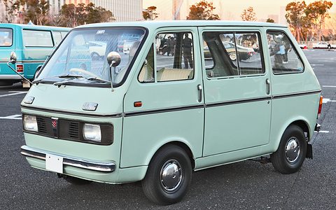 Mint-green cab-over van with a chrome bumper on a car park in evening light. Opens a larger view