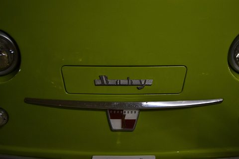 Close view of a green panel with a chrome Baby script, a chrome bar and a small red-and-white badge. Opens a larger view