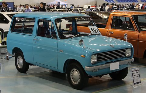 Light blue small van with a bonnet among other cars in a hall. Opens a larger view