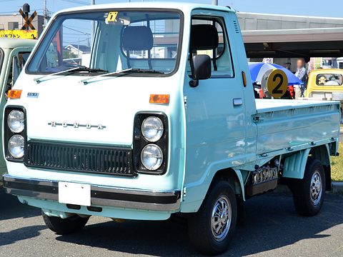 Pale blue cab-over pickup with twin headlamps seen from the front. Opens a larger view