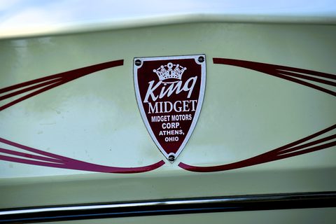 Maroon shield badge with a crown and the words King Midget, Midget Motors Corp, Athens, Ohio, between maroon pinstripes on cream paint. Opens a larger view