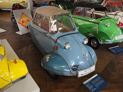 Pale blue tandem bubble car with a beige fabric roof, a KR 175 Messerschmitt plate on its nose. Opens a larger view