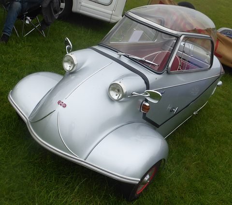 Silver bubble car with red interior on a lawn. Opens a larger view