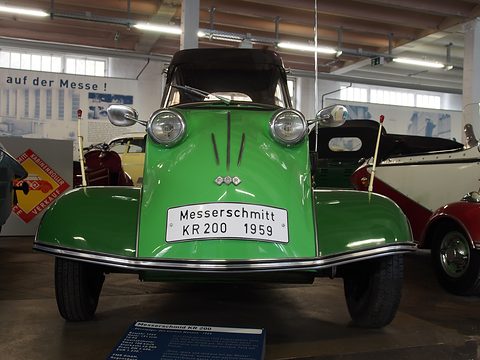 Green three-wheeler with black soft top and a plate reading Messerschmitt KR 200 1959. Opens a larger view