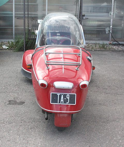 Red tail with chrome rack, twin lamps and registration TA-9, seen straight from behind. Opens a larger view