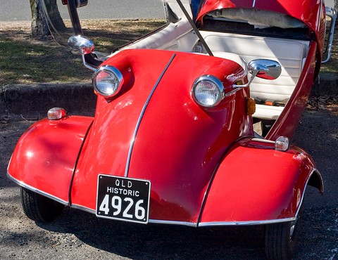 Red bubble car nose with two headlamps and a QLD Historic 4926 plate, canopy open. Opens a larger view