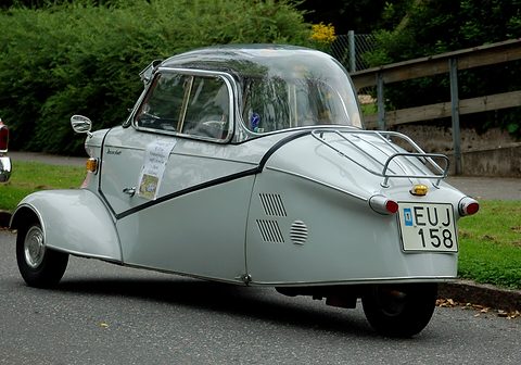 Silver-grey tapering tail with chrome rack and registration EUJ 158 on a road edge. Opens a larger view