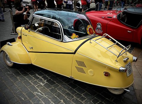 Yellow tapering tail with chrome rack and louvres on cobbles, photographers behind. Opens a larger view