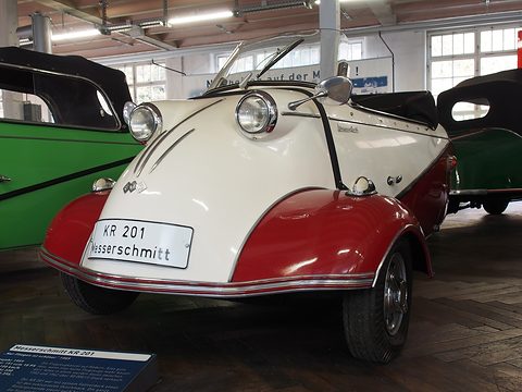 White and red open microcar with a KR 201 Messerschmitt plate, green cars either side. Opens a larger view