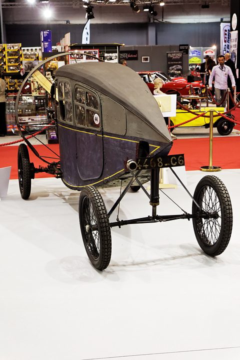 Rear view of an enclosed propeller car with a tapering navy body and two close-set rear wheels. Opens a larger view