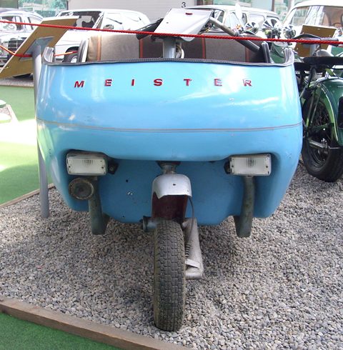 Pale blue open body with MEISTER lettering across the tail above a single rear wheel, on gravel. Opens a larger view