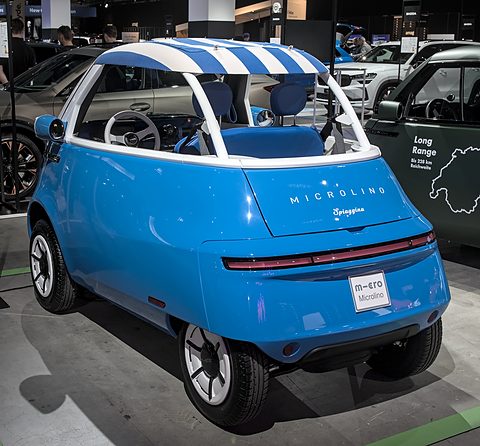Rear of an open blue bubble car with a striped canopy and Spiaggina script, a Micro plate on its tail. Opens a larger view