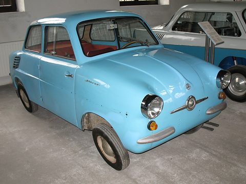 Pale blue small saloon on a concrete floor with a chrome nose bar and red upholstery visible. Opens a larger view