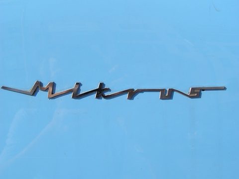 Chrome Mikrus script in slanted handwriting on pale blue paint. Opens a larger view