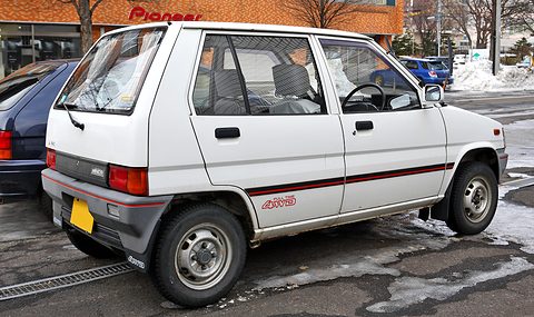 Rear three-quarter of a white hatchback with 4WD lettering on its mudflap, snow behind. Opens a larger view