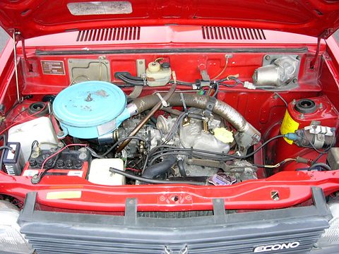Engine bay of a red car with a blue air cleaner, hoses and an ECONO grille below. Opens a larger view
