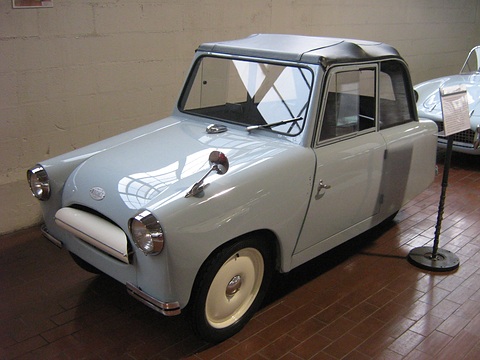 Pale blue small two-seat coupé with a grey top, round headlamps and cream wheels. Opens a larger view