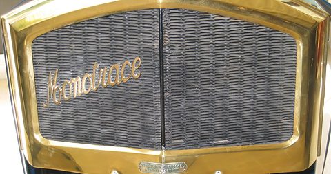 A brass radiator shell around a dark honeycomb core with the word Monotrace in flowing script. Opens a larger view