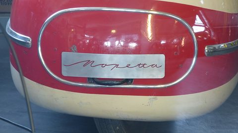 Red and cream nose with an oval chrome surround framing a brushed plate engraved Mopetta. Opens a larger view