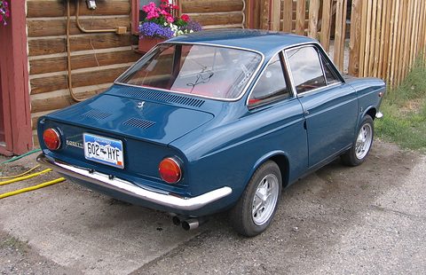 Rear quarter of a dark blue fastback with an engine-lid grille, round tail lamps and a Colorado plate. Opens a larger view