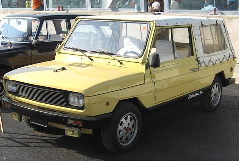 Yellow boxy open-sided leisure car with a white soft top and black bumpers, parked among other cars.