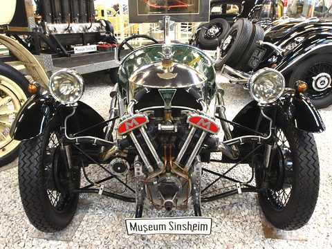 Front view of a three-wheeler with a Matchless V-twin, two headlamps and a Museum Sinsheim plate. Opens a larger view