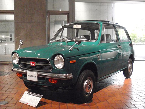 Dark green small saloon on a terracotta tiled floor with a placard in front. Opens a larger view
