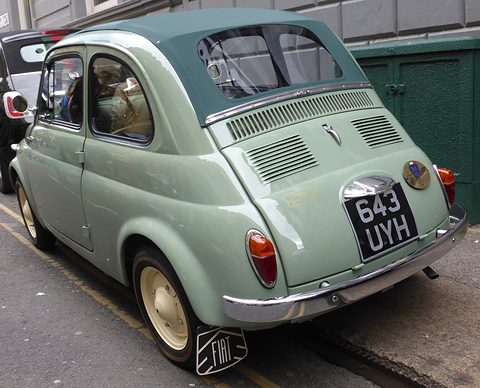 Pale green Fiat 500 from the rear left with cream wheels, a louvred lid and a Fiat mud flap. Opens a larger view