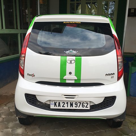 Rear of a white small hatchback with green stripes, a glass tailgate and Twist and XT badges.