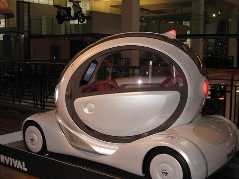 White bubble-shaped concept with its glass cabin rotated to face sideways on a display plinth.