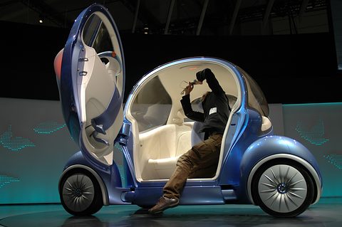 Blue bubble concept with a tall door swung up and a demonstrator reclining inside with an arm across his face. Opens a larger view