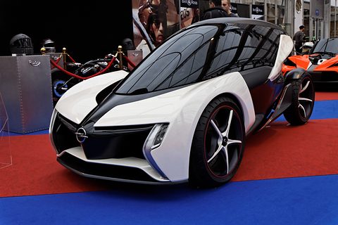 White and black low two-seat tandem concept with a dark canopy on a red and blue carpet. Opens a larger view