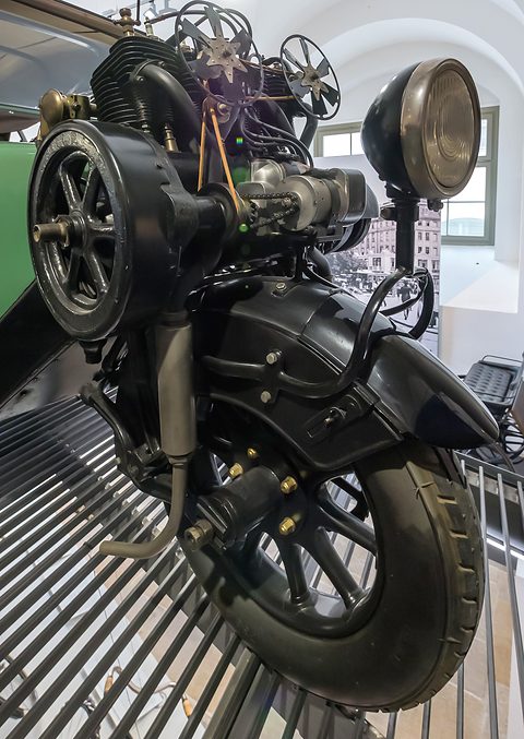 Front wheel with a mudguard and a large headlamp, the engine and fans above it. Opens a larger view