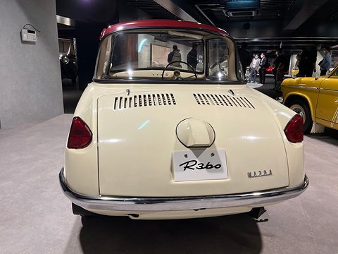 Rear view of a cream coupé with a maroon roof, louvred lid and an R360 plate. Opens a larger view