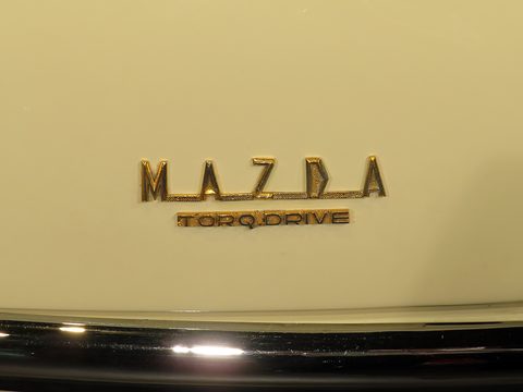 Gold letters reading MAZDA above a smaller TORQDRIVE badge on cream paint.