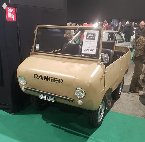 Beige open miniature off-roader with RANGER in black letters on its nose and a price card on the windscreen, crowds behind. Opens a larger view