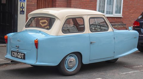 Pale blue three-wheeler with a cream roof and backward-sloping rear window seen from behind.